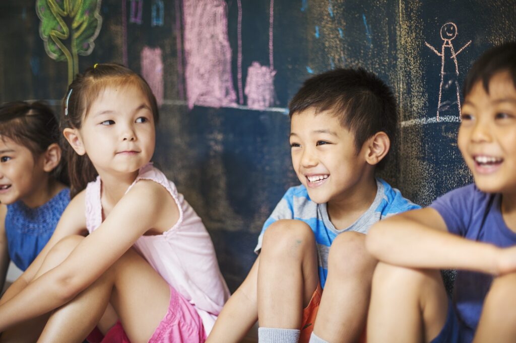 A group of children in school. Boys and girls sitting on the floor.